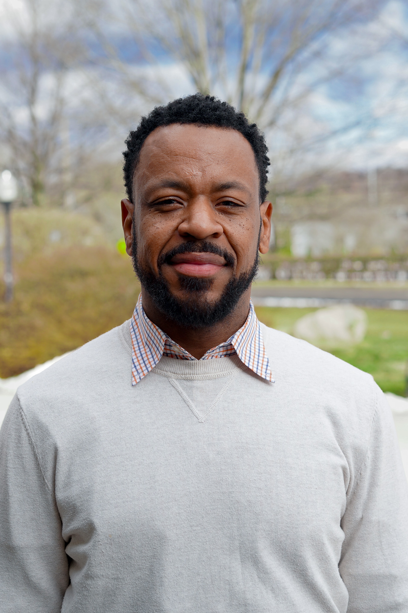 Man in sweater with white collar sticking through