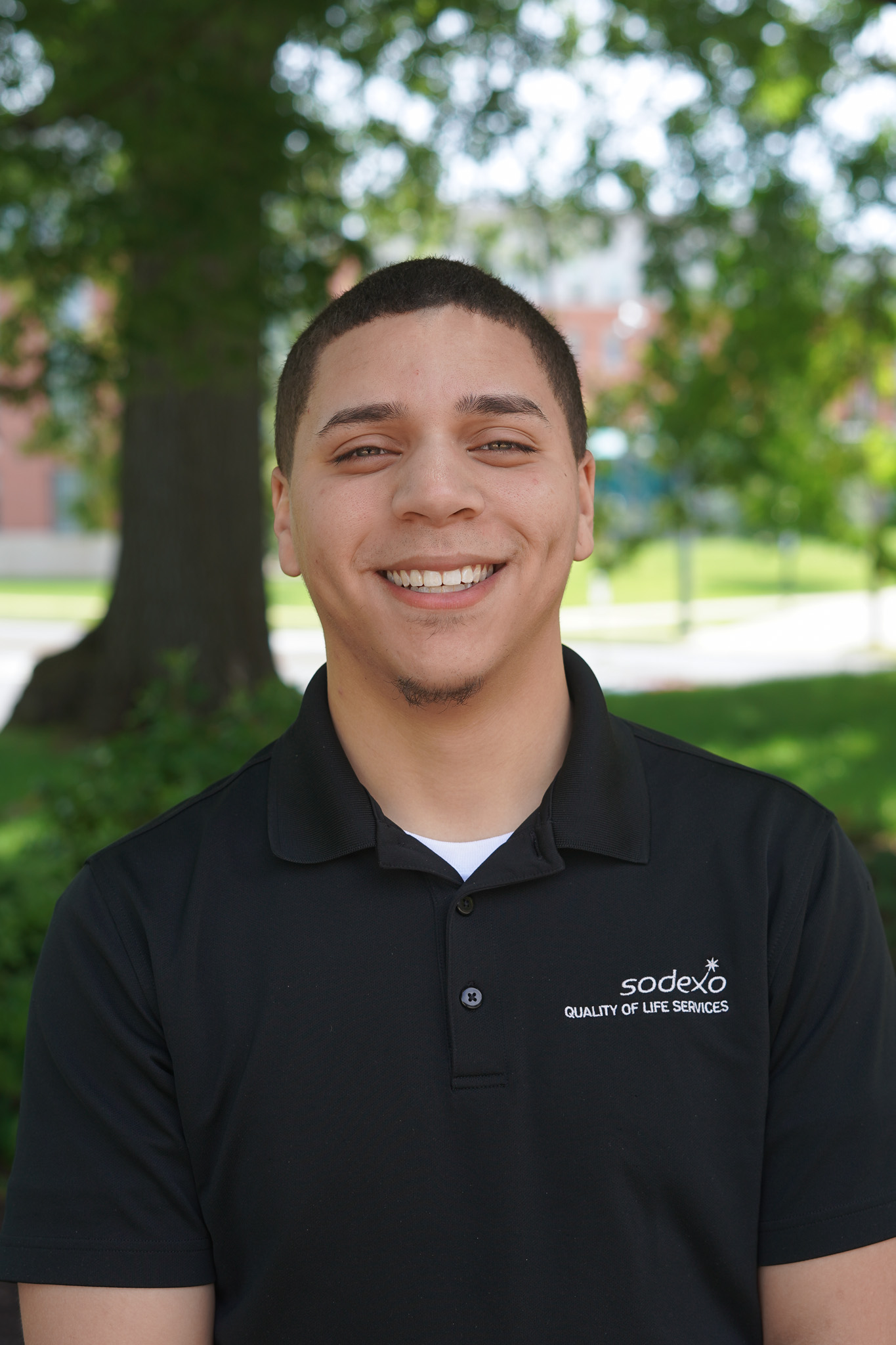Men in a black polo shirt standing outdoors